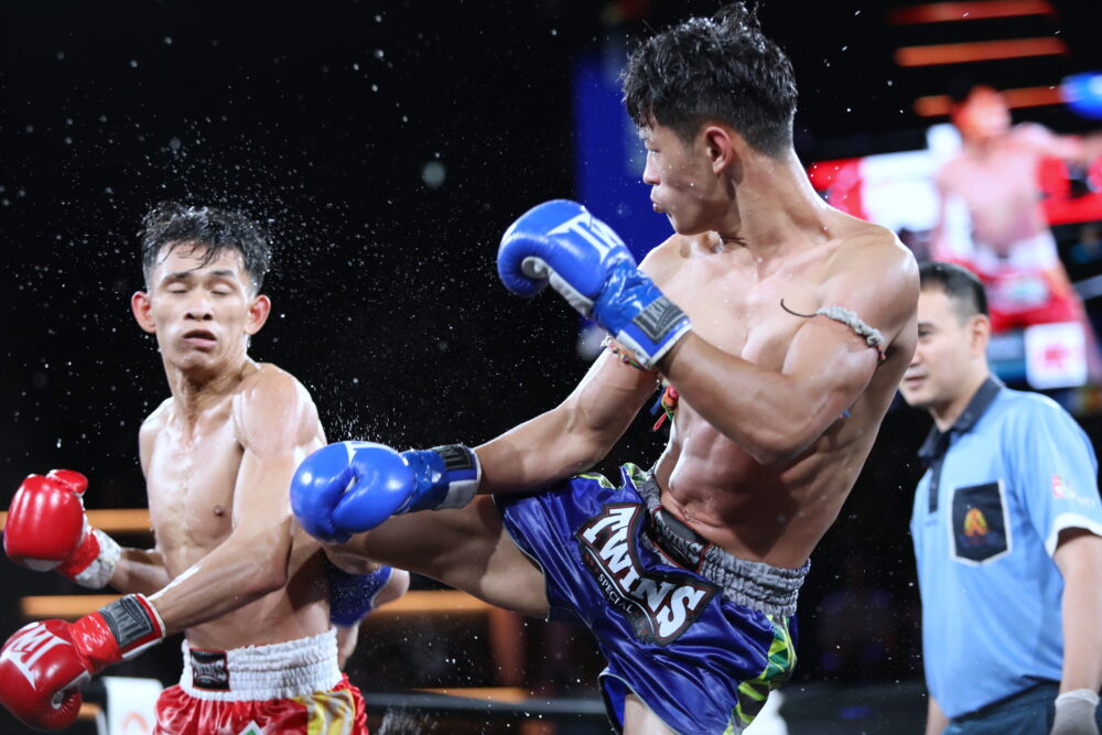 fighter kicks another fighter in the back at rajadamnern stadium